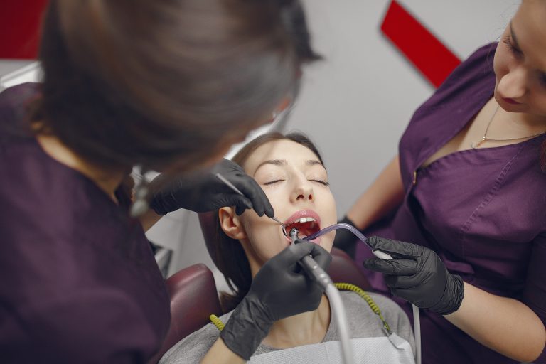 Beautiful lady in the dentist's office. Woman in a purple uniform